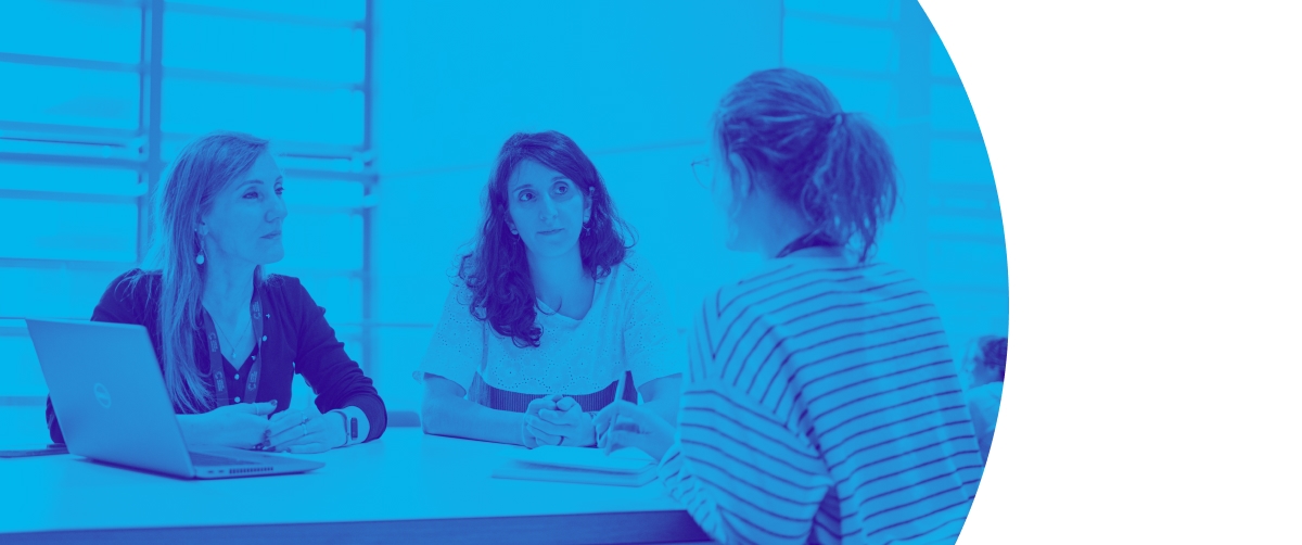 Several people in a meeting room in discussion.