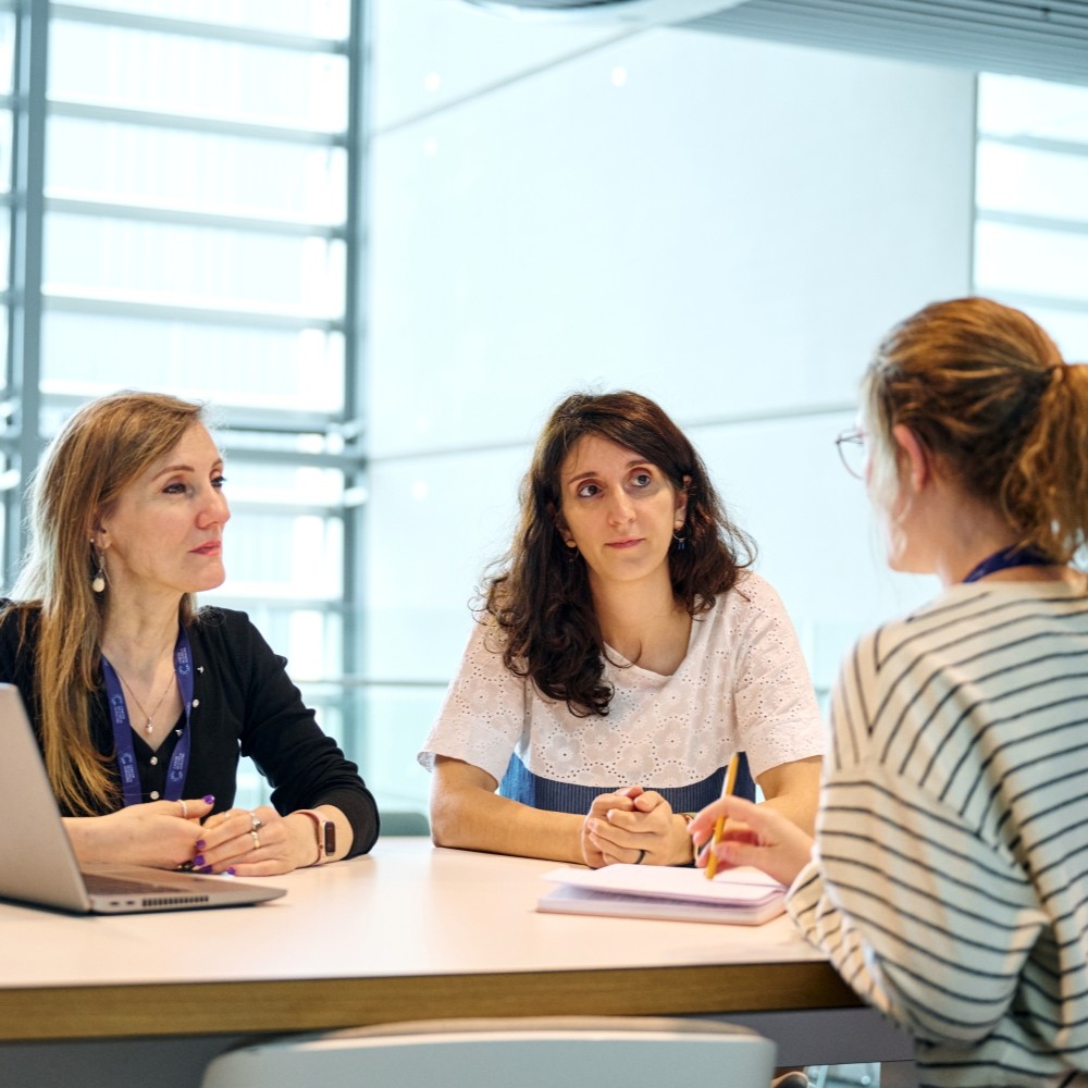 People sat in a meeting, having a serious discussion.